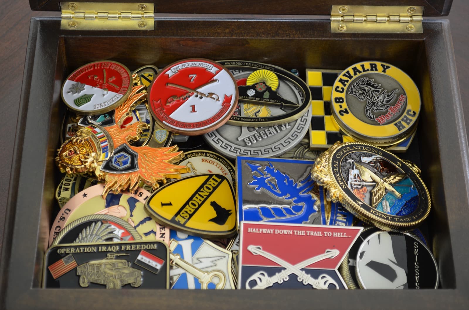 Close-up of military challenge coins inside a wooden box